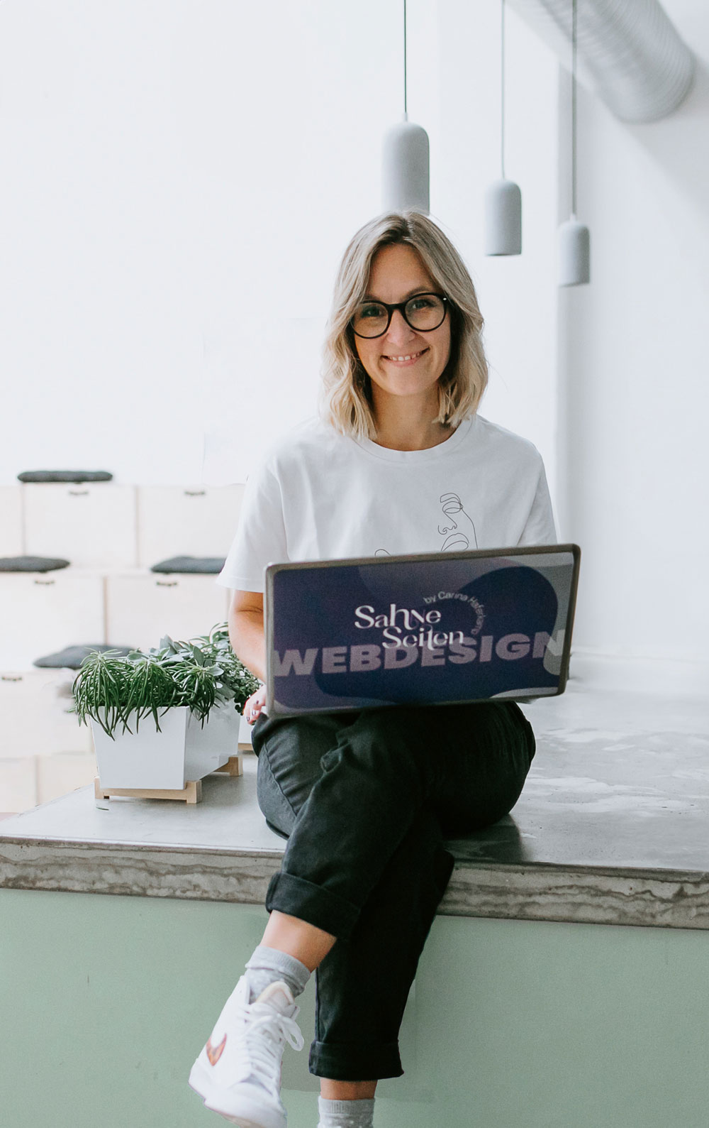 Carina Haferkamp erstellt Website mit Laptop auf dem Schoß