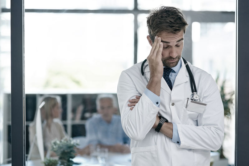 hospital doctor man with headache stress worry medical career job work with patients professional healthcare person with pain overworked burnout frustrated